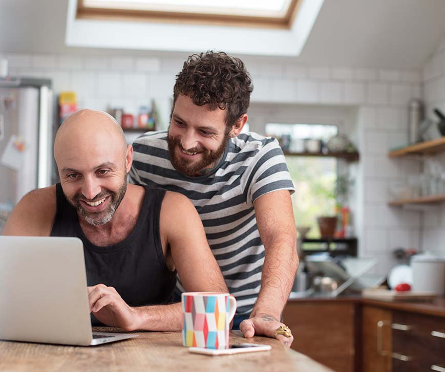 happy gay couple searching on computer
