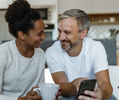 Excited couple checking out real estate news on their phone