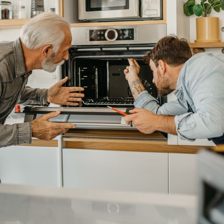 Twee mannen die een oven onderzoeken.